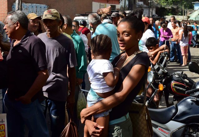 People queue to buy basic food and household items outside a market in the poor neighbourhood of Petare on June 10, 2016. Venezuela President Nicolas Maduro faces mounting protests over shortages of food, medicine, electricity and water. / AFP PHOTO / RONALDO SCHEMIDT