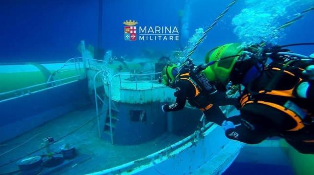 Fotografía facilitada por la marina italiana, hoy, 29 de junio de 2016, que muestra a buzos de la marina italiana que exploran una barcaza hundida en el fondo del mar que se hundió en 2015 con unos 700 inmigrantes a bordo ayer. El barco ha sido reflotado a la superficie desde una profundidad de más de 365 metros. El navío ha sido conservado en una estructura refrigerante para trasladarlo hasta tierra a fin de que los forenses puedan identificar los cuerpos de las víctimas. EFE/Italian Navy Press Office