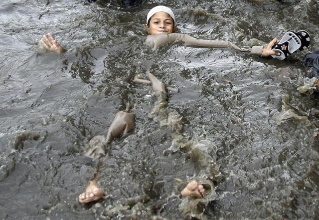 Un niño juega en una calle inundada en Karachi (Pakistán) hoy, 29 de junio de 2016. Al menos 11 personas han muerto con motivo de las fuertes lluvias registradas los últimos días. EFE/Shahzaib Akber