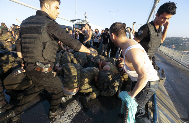 A police officer protects urrendered Turkish soldiers who were involved in the coup on Bosphorus bridge in Istanbul, Turkey, July 16, 2016. REUTERS/Stringer EDITORIAL USE ONLY. NO RESALES. NO ARCHIVES.