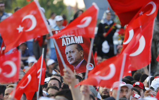 People wave flags as they wait for Turkish President Tayyip Erdogan to appear for a speech outside his residence in Istanbul, Turkey, July 16, 2016. REUTERS/Murad Sezer TPX IMAGES OF THE DAY