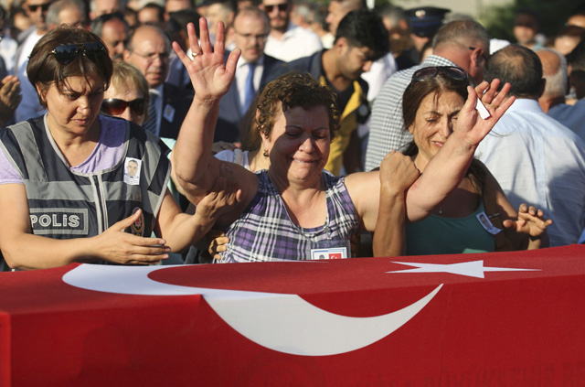 Women mourn over the coffin holding body of police officer Nedip Cengiz Eker during a funeral ceremony in Marmaris, Turkey, July 16, 2016. REUTERS/Kenan Gurbuz