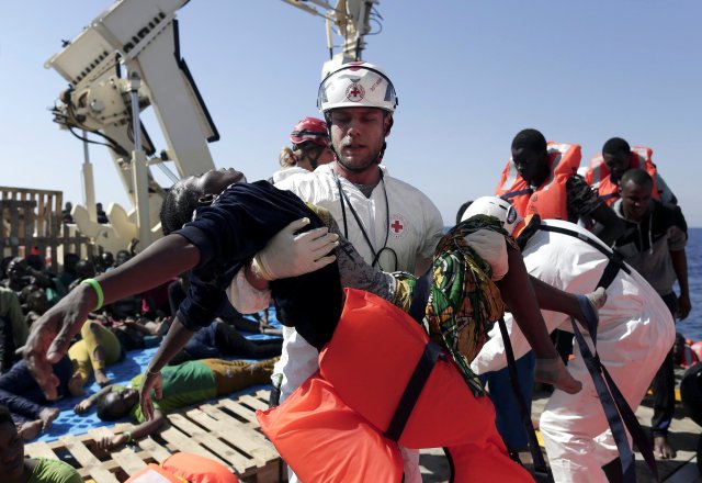 A member of Italian Red Cross carries a migrant during a rescue operation of the Migrant Offshore Aid Station (MOAS) rescue vessel Phoenix in the international waters between Malta and Libya on August 10,2016. REUTERS/Yara Nardi FOR EDITORIAL USE ONLY. NO RESALES. NO ARCHIVES.