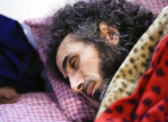 El sirio Abu Wa'el Dhiab, un ex detenido de Guantánamo, descansa en la cama mientras conversa con su familia a través de un ordenador portátil en su apartamento en Montevideo, Uruguay, el viernes 9 de septiembre de 2016. (AP Foto/Matilde Campodonico)