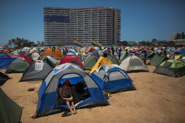 Una pareja descansa dentro de una casa de campaña instalada en el llamado "Campamento Revolucionario" levantado a inicios de semana para recibir a miles de jóvenes oficialistas durante la XVII Cumbre del Movimiento de los Países No Alineados, en Porlamar, isla de Margarita, Venezuela, el viernes 16 de septiembre de 2016. (AP Foto/Ariana Cubillos)