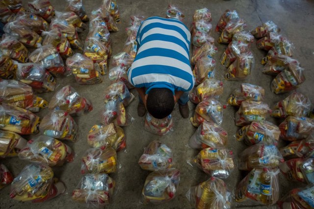 ACOMPAÑA CRÓNICA: VENEZUELA ALIMENTOS - CAR01. CARACAS (VENEZUELA), 28/08/2016.- Fotografía del 20 de agosto del 2016, donde se observan un operativo de entrega de bolsas de comida a habitantes de un barrio del km 3 del Junquito por parte Comités Locales de Abastecimiento y Producción (CLAP) en Caracas (Venezuela). La severa escasez de productos básicos en Venezuela ha llevado a que la foto diaria del país sea una inmensa fila frente a muchos abastos y supermercados, un problema que el Gobierno intenta solucionar con un sistema de venta de alimentos, conformado solo por militantes chavistas, conocido como CLAP. EFE/MIGUEL GUTIÉRREZ