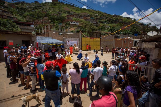 ACOMPAÑA CRÓNICA: VENEZUELA ALIMENTOS - CAR01. CARACAS (VENEZUELA), 28/08/2016.- Fotografía del 20 de agosto del 2016, donde se observa un grupo de bailarinas durante un operativo de entrega de bolsas de comida a habitantes de un barrio del km 3 del Junquito por parte Comités Locales de Abastecimiento y Producción (CLAP) en Caracas (Venezuela). La severa escasez de productos básicos en Venezuela ha llevado a que la foto diaria del país sea una inmensa fila frente a muchos abastos y supermercados, un problema que el Gobierno intenta solucionar con un sistema de venta de alimentos, conformado solo por militantes chavistas, conocido como CLAP. EFE/MIGUEL GUTIÉRREZ