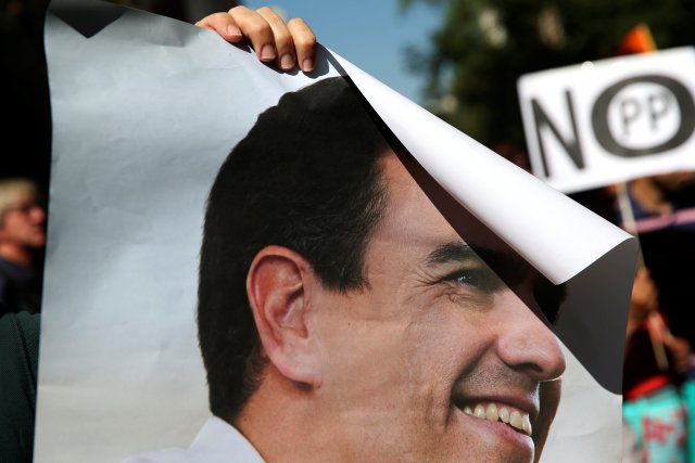 A supporter of Spain's Socialist party (PSOE) leader Pedro Sanchez holds his poster outside the party's headquarters during the party's assembly meeting in Madrid, Spain, October 1, 2016. REUTERS/Susana Vera