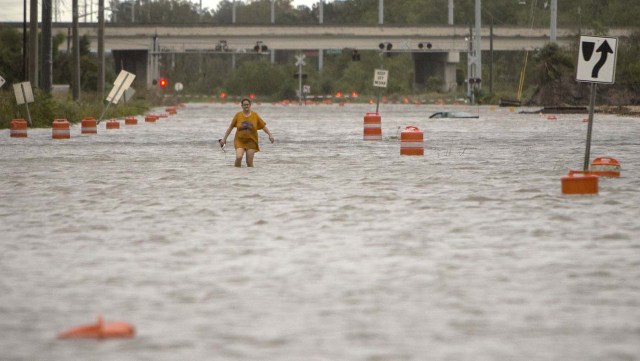 Una mujer que dijo llamarse solo Valerie camina por la calle President, que se inundó tras el paso del huracán Matthew, tras salir del campamento para personas desamparadas, el sábado 8 de octubre del 2016 en Savannah, Georgia. El huracán Matthew se ha debilitado a tormenta categoría 1 pero sigue siendo una amenaza para las costas de Georgia y las Carolinas. El Centro Nacional de Huracanes en Miami dijo el sábado por la mañana que Matthew estaba centrado a unos 30 kilómetros (20 millas) al sur-sureste de Charleston, South Carolina. (AP Foto/Stephen B. Morton)