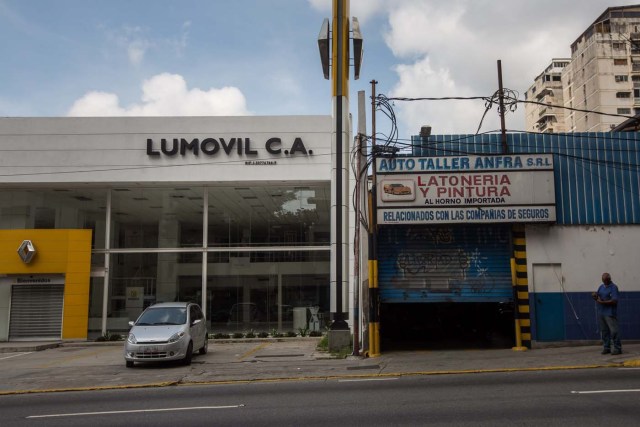 CAR01. CARACAS (VENEZUELA), 28/10/2016.- Un local comercial abierto y otro cerrado vistos hoy, viernes 28 de octubre de 2016, en Caracas (Venezuela). El paro general de 12 horas convocado por la oposición venezolana se cumple a medias en el país pues tanto las entidades bancarias como algunos comercios y oficinas abrieron sus puertas, sin embargo, las principales vías se mostraron con mucho menos tráfico que el que se observa en un día laboral normal. EFE/MIGUEL GUTIÈRREZ