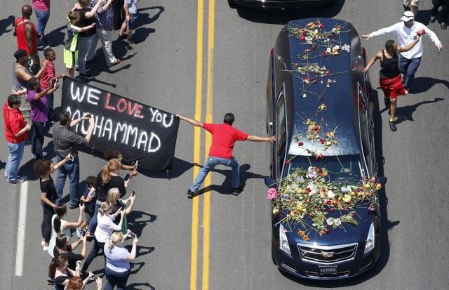 FILE PHOTO - A well-wisher holding a banner touches the hearse carrying the remains of Muhammad Ali during the funeral procession for the three-time heavyweight boxing champion in Louisville, Kentucky, U.S., June 10, 2016. REUTERS/Adrees Latif/File Photo REUTERS PICTURES OF THE YEAR 2016 - SEARCH 'POY 2016' TO FIND ALL IMAGES