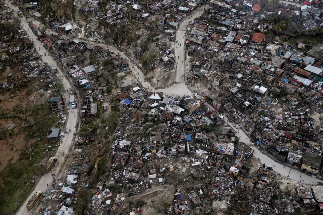 FILE PHOTO - People walk down the streets next to destroyed houses after Hurricane Matthew passes Jeremie, Haiti, October 5, 2016. REUTERS/Carlos Garcia Rawlins/File Photo REUTERS PICTURES OF THE YEAR 2016 - SEARCH 'POY 2016' TO FIND ALL IMAGES