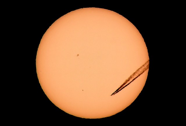 FILE PHOTO - A jet airliner leaves a vapor trail as the planet Mercury is seen, lower left quadrant, transiting across the face of the sun in Las Vegas, Nevada, May 9, 2016. REUTERS/David Becker/File Photo REUTERS PICTURES OF THE YEAR 2016 - SEARCH 'POY 2016' TO FIND ALL IMAGES