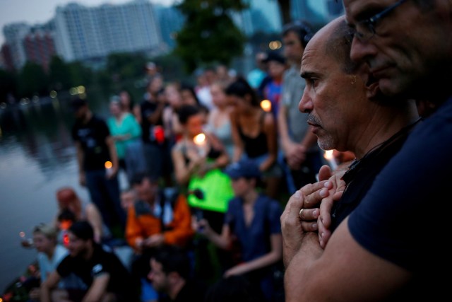 FILE PHOTO - Wilfredo Perez (L), a local bartender at a gay bar, is embraced by his partner Jackson Hollman during a vigil to commemorate victims of a mass shooting at the Pulse gay night club in Orlando, Florida, U.S., June 12, 2016. REUTERS/Adrees Latif/File Photo REUTERS PICTURES OF THE YEAR 2016 - SEARCH 'POY 2016' TO FIND ALL IMAGES