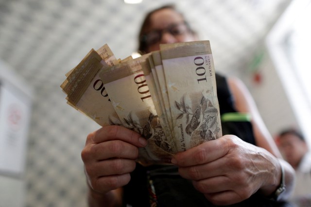 A cashier counts Venezuelan bolivar notes inside a restaurant in downtown Caracas, Venezuela, December 12, 2016. REUTERS/Ueslei Marcelino