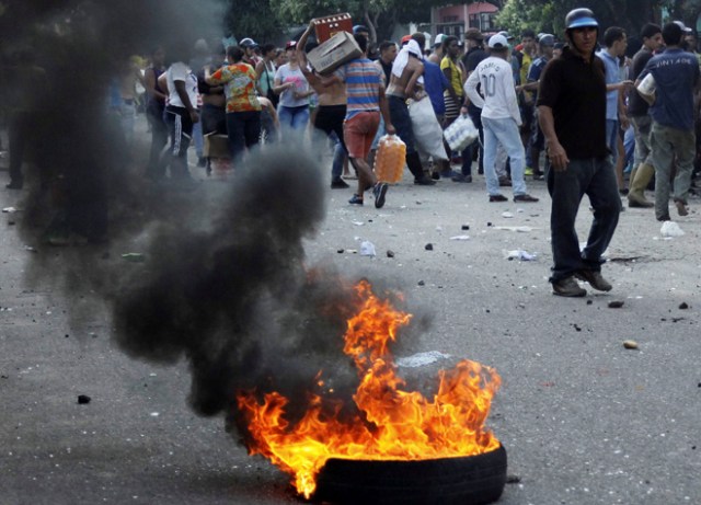 People carry goods taken from a food wholesaler after it was broken into, in La Fria, Venezuela December 17, 2016. REUTERS/Carlos Eduardo Ramirez