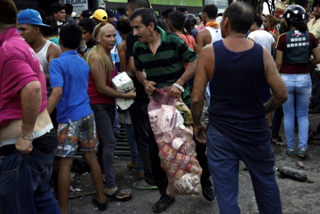 People carry goods taken from a food wholesaler after it was broken into, in La Fria, Venezuela December 17, 2016. REUTERS/Carlos Eduardo Ramirez