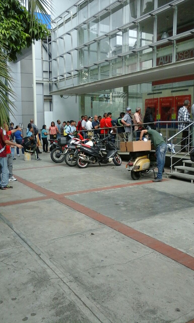 Venezolanos dejan de hacer colas en supermercados y farmacias para rogar por su dinero (FOTOS)