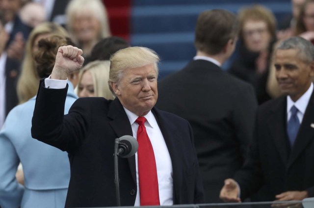 Outgoing U.S. President Barack Obama (R) looks on as U.S. President Donald Trump raises his fist after being sworn in as the 45th president of the United States on the West front of the U.S. Capitol in Washington, U.S., January 20, 2017. REUTERS/Carlos Barria