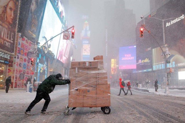 A man attempts to deliver packages in Times Square as heavy snow falls in Manhattan, New York, U.S. February 9, 2017. REUTERS/Andrew Kelly