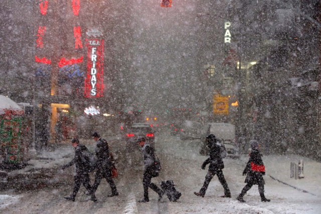 Pedestrians walk in Times Square as snow falls in Manhattan, New York, U.S. February 9, 2017. REUTERS/Andrew Kelly