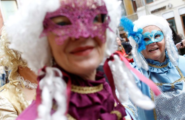 Masked revellers pose during the Venice Carnival in Venice, Italy February 11, 2017. REUTERS/Tony Gentile