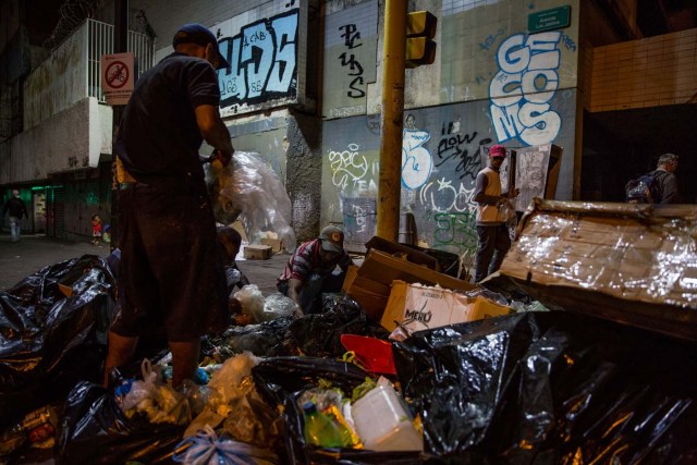 ACOMPAÑA CRÓNICA: VENEZUELA CRISIS. CAR10. CARACAS (VENEZUELA), 31/12/2016.- Varias personas buscan comida entre bolsas de basura este jueves, 31 de diciembre de 2016, en Caracas (Venezuela). La profunda crisis que aqueja a Venezuela trajo como consecuencia escasez y hambre, lo que a su vez ha llevado a familias enteras a buscar restos de alimentos en los basureros y, muchas veces, a pelear con otras personas sin recursos, por un desecho comestible o algún material reciclable que se pueda vender. EFE/Miguel Gutiérrez