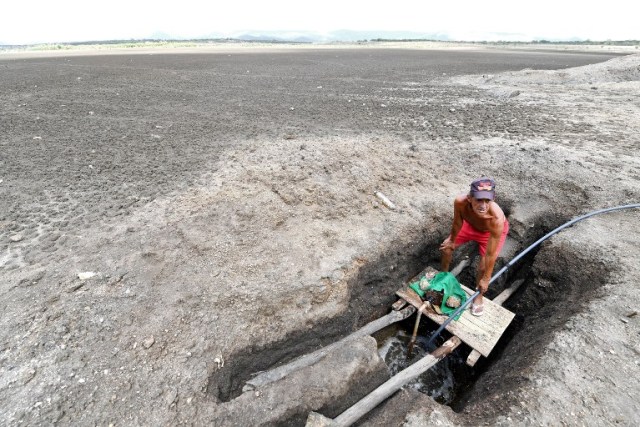 A man operates a water pump at the dry Cedro reservoir in Quixada, Ceara State, on February 8, 2017. The situation of Brazil's oldest reservoir sumps up the devastiting effects -human and environmental- of the worst drought of the century in the northeast of the country. / AFP PHOTO / EVARISTO SA / TO GO WITH AFP STORY BY CAROLA SOLE