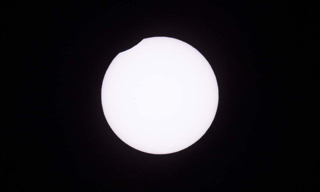 Picture taken on February 26, 2017 showing the moon moving to cover the sun for an annular solar eclipse, as seen from the Estancia El Muster, near Sarmiento, Chubut province, 1600 km south of Buenos Aires, Argentina, on February 26, 2017.  Stargazers applauded as they were plunged into darkness Sunday when the moon passed in front of the sun in a spectacular "ring of fire" eclipse. / AFP PHOTO / ALEJANDRO PAGNI