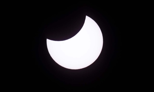 Picture taken on February 26, 2017 showing the moon moving to cover the sun for an annular solar eclipse, as seen from the Estancia El Muster, near Sarmiento, Chubut province, 1600 km south of Buenos Aires, Argentina, on February 26, 2017. Stargazers applauded as they were plunged into darkness Sunday when the moon passed in front of the sun in a spectacular "ring of fire" eclipse. / AFP PHOTO / ALEJANDRO PAGNI