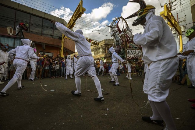 Revellers dance in the carnival parade in the mining village of El Callao, Bolivar state, southeastern Venezuela on February 27, 2017. El Callao's carnival was recently named Unesco's Intangible Cultural Heritage of Humanity. / AFP PHOTO / JUAN BARRETO / TO GO WITH AFP STORY BY ISABEL SANCHEZ