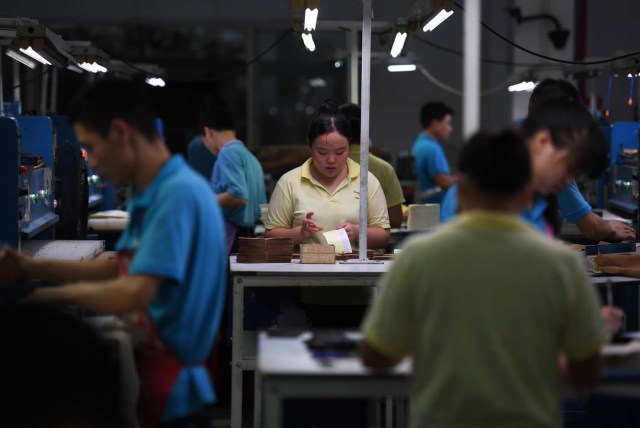 (FILES) This file photo taken on September 14, 2016 shows workers on a production line at the Huajian shoe factory, where about 100,000 pairs of Ivanka Trump-branded shoes have been made over the years amongst other brands, in Dongguan in south China's Guangdong province. In his January inauguration speech, US President Donald Trump made a seemingly straightforward pledge: "We will follow two simple rules: buy American and hire American." His daughter is the exception: even as he spoke, at least eight shipments of Ivanka Trump-branded shoes, bags and clothes -- more than 53.5 tonnes -- were steaming towards American ports from China, according to US Customs bills of lading examined by AFP. / AFP PHOTO / Greg Baker / TO GO WITH China-US-politics-economy-trade-Trump, FOCUS by Ben DOOLEY