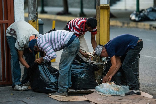 Personas buscan en la basura algopara comer ante la crisis actual en Venezuela. / AFP PHOTO / Federico PARRA