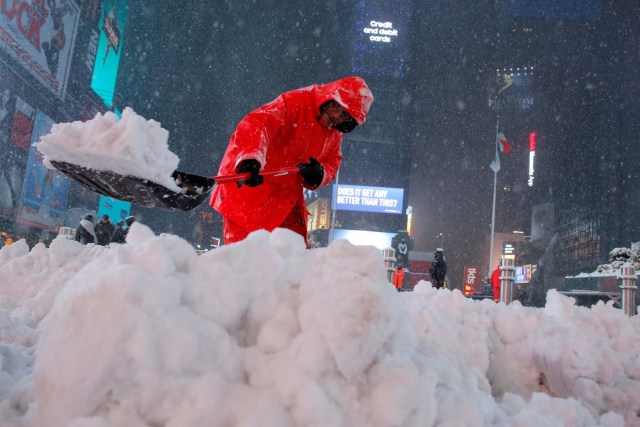 A worker clears snow in Times Square as snow falls in Manhattan, New York, U.S., March 14, 2017. REUTERS/Andrew Kelly