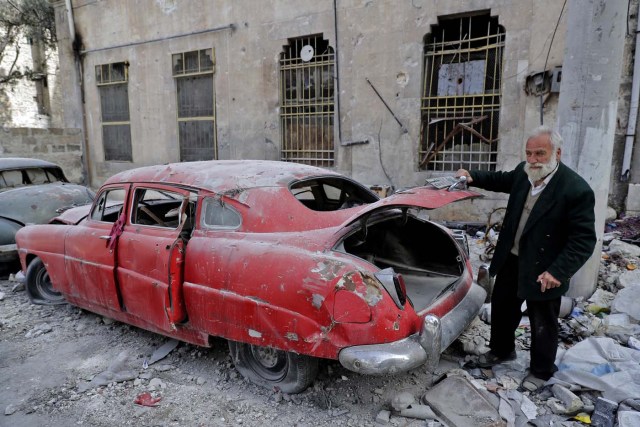 A picture taken on March 9, 2017, shows 70-year-old Mohammed Mohiedin Anis, or Abu Omar, opening the trunk of his 1949 Hudson Commodor outside his home in Aleppo's formerly rebel-held al-Shaar neighbourhood.  / AFP PHOTO / JOSEPH EID