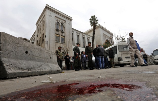 Syrian security forces cordon off the area following a reported suicide bombing at the old palace of justice building in Damascus on March 15, 2017. A suicide bomber attacked the courthouse in the centre of the Syrian capital, killing at least 25 people and wounding others, state media reported. / AFP PHOTO / Louai Beshara