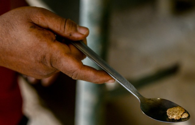 A man shows a gold stone at a gold mine in El Callao, Bolivar state, southeastern Venezuela on February 25, 2017. Although life in the mines of eastern Venezuela is hard and dangerous, tens of thousands from all over the country head for the mines daily in overcrowded trucks, pushed by the rise in gold prices and by the severe economic crisis affecting the country, aggravated recently by the drop in oil prices. / AFP PHOTO / JUAN BARRETO / TO GO WITH AFP STORY by Maria Isabel SANCHEZ