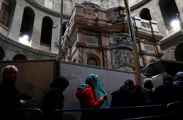 Visitantes cerca de recién restaurado Edículo en la iglesia del Santo Sepulcro de Jerusalén, Israel, el 20 de marzo de 2017.