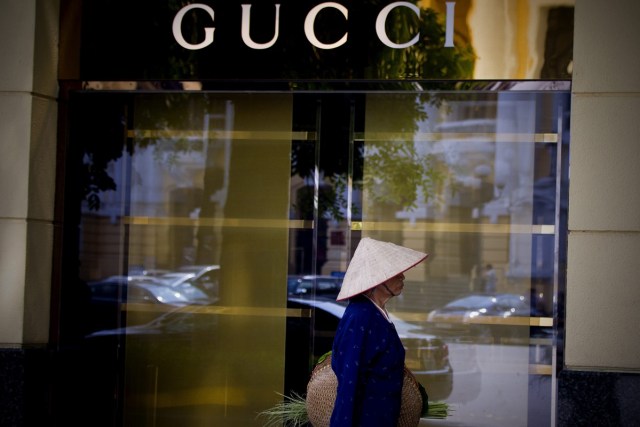 LIN02 HANOI (VIETNAM) 18/09/2013.- Una mujer camina junto a una tienda de Gucci en Hanoi (Vietnam) hoy, miércoles 18 de septiembre de 2013. Los millonarios en Vietnam han aumentado en un 14,7 por ciento en 2013. Un total de 195 personas tienen un patrimonio por encima de los 30 millones de dólares. EFE/Luong Thai Linh