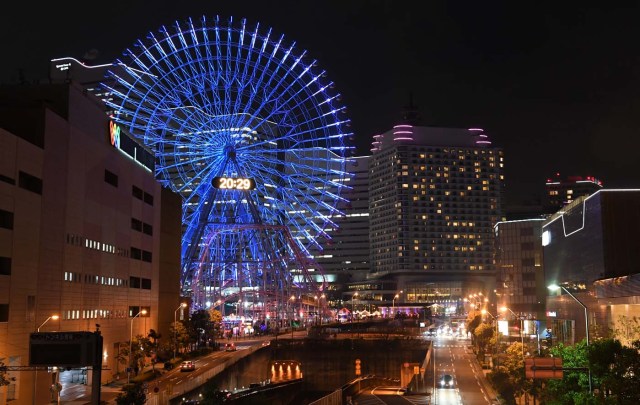 The Yokohama giant ferris wheel, Cosmo Clock 21, is seen moments before its lights were turned off for the Earth Hour environmental campaign in Yokohama on March 25, 2017. / AFP PHOTO / Toshifumi KITAMURA