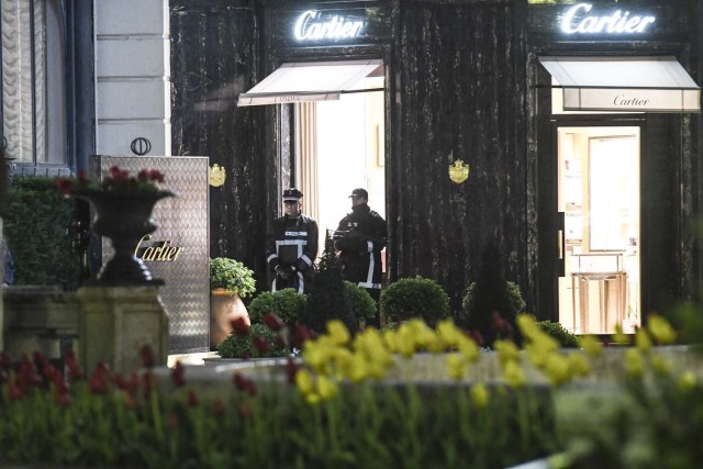 Monaco's police officers stand guard in front of the Cartier jewellery boutique after it was robbed in downtown Monaco on March 25, 2017. Monaco police were hunting for two suspects on March 25 after a daring afternoon robbery at the famous French jeweller Cartier, prompting a brief lockdown of the tiny principality and jet set haven. / AFP PHOTO / Yann COATSALIOU