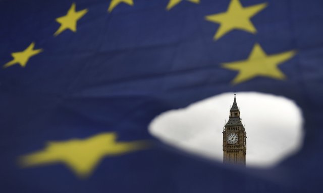 -FOTODELDIA- ARA111 LONDRES (REINO UNIDO) 29/03/2017.- El Big Ben asoma por un roto en una bandera de la Unión Europea en Londres (Reino Unido) hoy, 29 de marzo de 2017. El Gobierno del Reino Unido ha solicitado a primera hora de la tarde oficialmente a la UE su deseo de abandonar el grupo, lo que activa el proceso de negociación establecido en el Tratado de Lisboa. EFE/Andy Rain