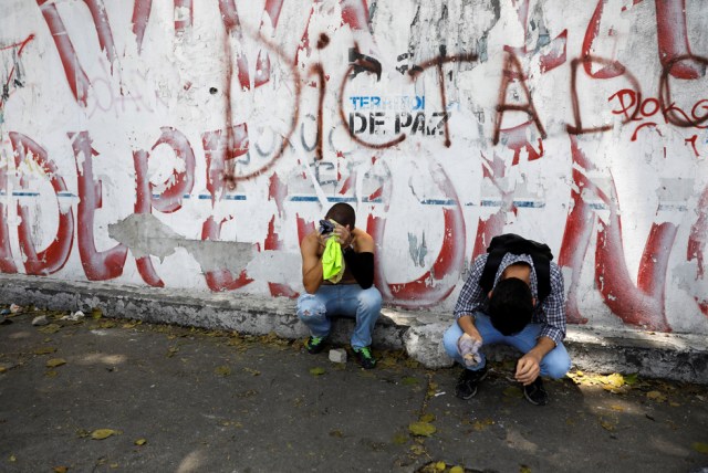 Demonstrators rest as the riot police clashes with opposition suporters during a rally in Caracas, Venezuela, April 8, 2017. REUTERS/Carlos Garcia Rawlins