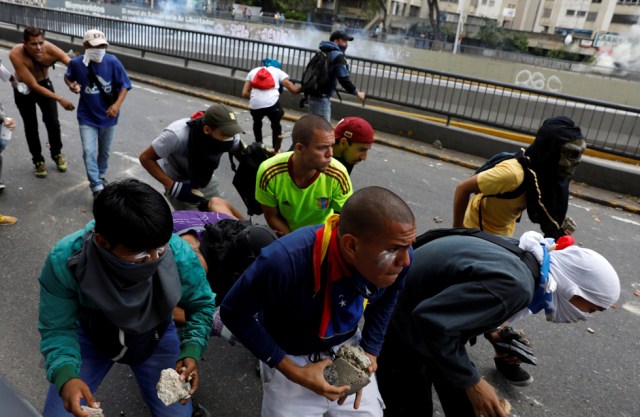 Demonstrators hold rocks as they clash with the riot police during a rally in Caracas, Venezuela, April 8, 2017. REUTERS/Carlos Garcia Rawlins