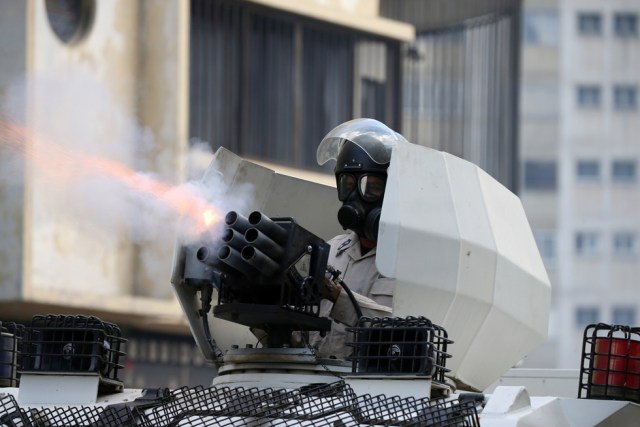 A riot police officer fires tear gas while clashing with demonstrators during a rally in Caracas, Venezuela, April 8, 2017. REUTERS/Carlos Garcia Rawlins