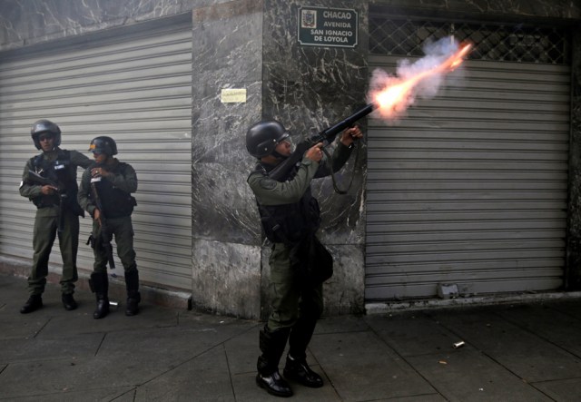 A riot police officer fires tear gas while clashing with demonstrators during a rally in Caracas, Venezuela, April 8, 2017. REUTERS/Marco Bello TPX IMAGES OF THE DAY