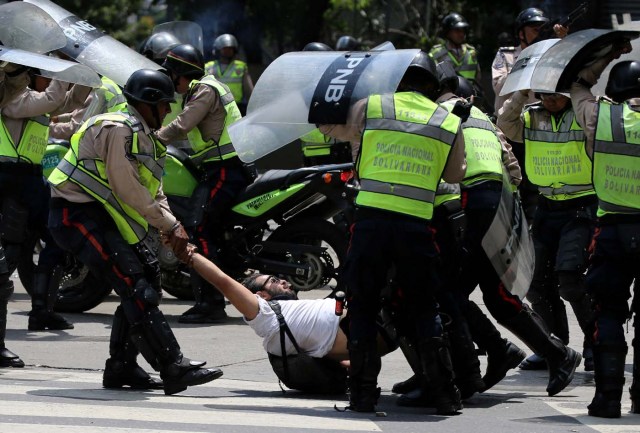 A demonstrator is arrested by riot police while rallying against Venezuela's President Nicolas Maduro's government in Caracas, Venezuela April 10, 2017. REUTERS/Carlos Garcia Rawlins