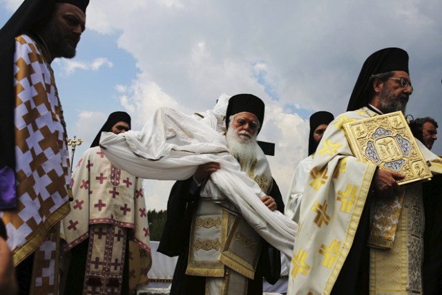 QBV191 ATENAS (GRECIA) 14/04/2017.-Sacerdotes ortodoxos griegos cargan con el cuerpo de Cristo tras bajarlo de la cruz durante el ritual Apokathelosis, de recreación de la bajada de Jesús de la cruz, en la iglesia del monasterio Pendeli en Atenas (Grecia) hoy, 14 de abril de 2017. EFE/Alexandros Vlachos