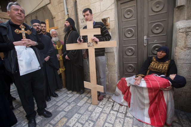 ATS16 JERUSALÉN (ISRAEL) 14/04/2017.- Una mujer musulmana con su hijo en brazos pide limosna al paso de varios creyentes cristianos que partiicpan en una procesión de Viernes Santo por la Vía Dolorosa en el casco viejo de Jerusalén (Israel) hoy, 14 de abril de 2017. EFE/Atef Safadi