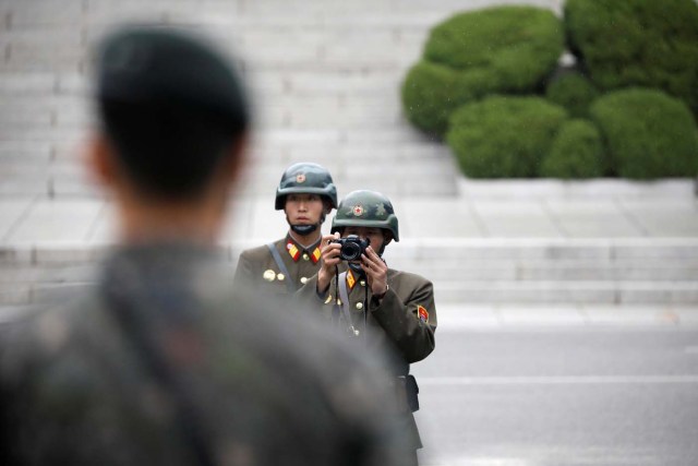 A North Korean soldier takes photographs as U.S. Vice President Mike Pence (not pictured) arrives at the truce village of Panmunjom, South Korea, April 17, 2017.  REUTERS/Kim Hong-Ji